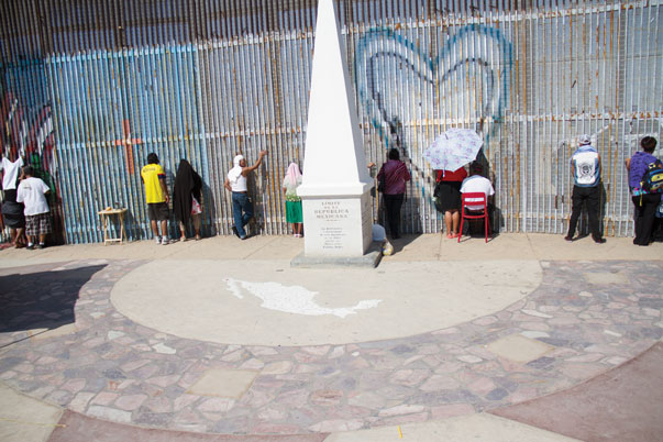 On the South side, families are allowed to walk up to the wall at any time. There are no restrictions and a police presence is only seen on occasion along the boardwalk. The people standing up against the wall are actually on U.S. soil, as the wall was built three feet behind the American territorial limit. The monument stands on top of that line. / Jorge Campos