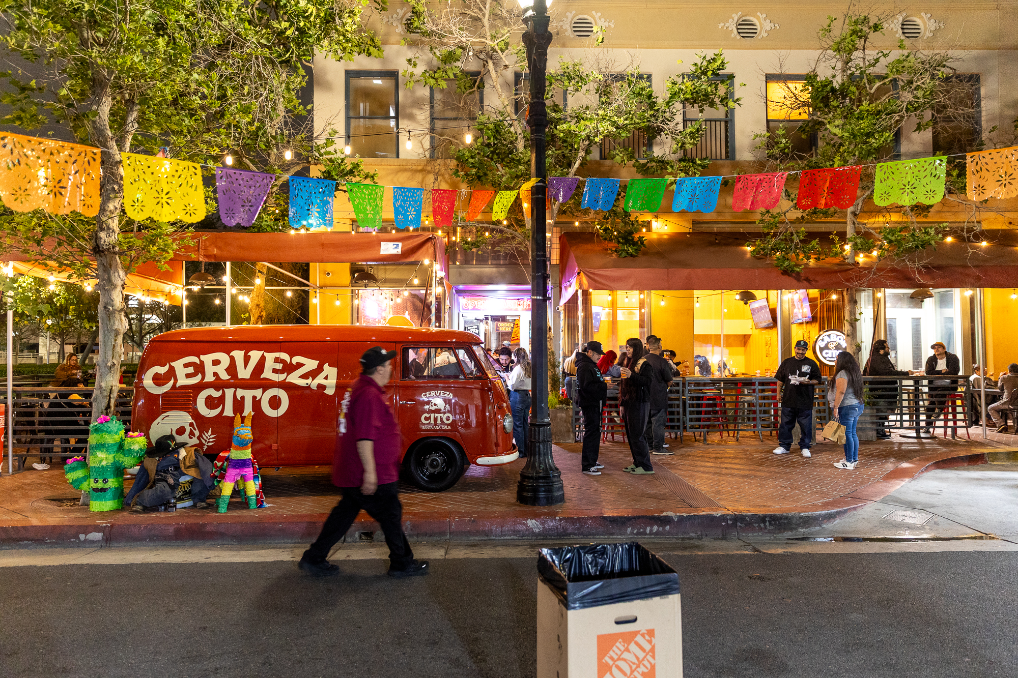 people hanging out outside a brewery at night