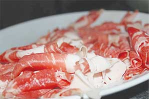 A plate of thinly sliced raw brisket