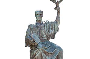 Statue of Alex Odeh with a bird perching on his hand while he was holding book with the other hand.