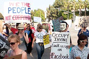 Protestors carry signs carrying signs in Orange County; one of the protestor was wearing the Fawkes mask.