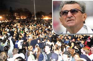 Cutout of coach Joe Paterno's photo on foreground with a big crowd of Penn State University students riots at nighta the background.