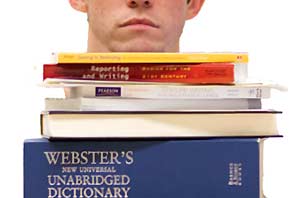 A student with a big stack of text book and Webster's Dictionary.