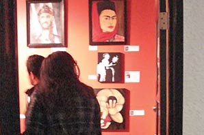 Visitors admiring art works on display.