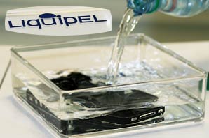 Water being poured into a glass container with a cell phone.