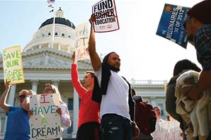 A group of students raising up signs such as Fund-Higher-Education, Save-our-Future, The-Millionaires-Tax-of-2012, I-have-A-Dream, protesting in front of the California State Capital building.