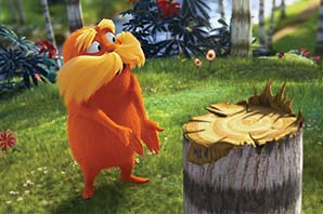 The animated Disney character Lorax standing by a tree trunk in the forest.