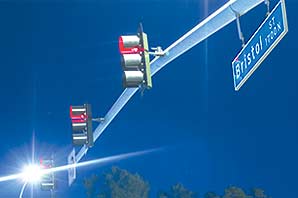 View from the ground toward a very blue sky of the metal rod holding the Bristol Street sign and traffic lights.