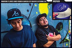 Marvin Flores and Ruben Garcia, both wearing caps by their KALM Clothing Company, stand against a wall with colorful murial. At the corner is a blue cap with white weaving pattern on the beak and Kalm logo on the front.