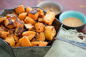 A bowl of copped and roasted potatoes that is in focused with other small bowls in the background.