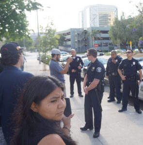 Cop Watch / Police cars lined Third Street from Flower to Ross and blocked off traffic for about half an hour, until the book fair ended and the inflammatory banner was taken down. 