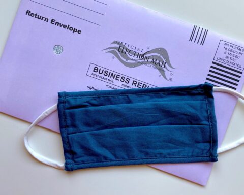 A cloth mask covering a mail-in ballot.