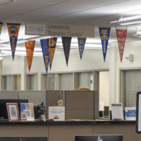 Transfer center check in desk displays the flags of the colleges most frequently transferred to .