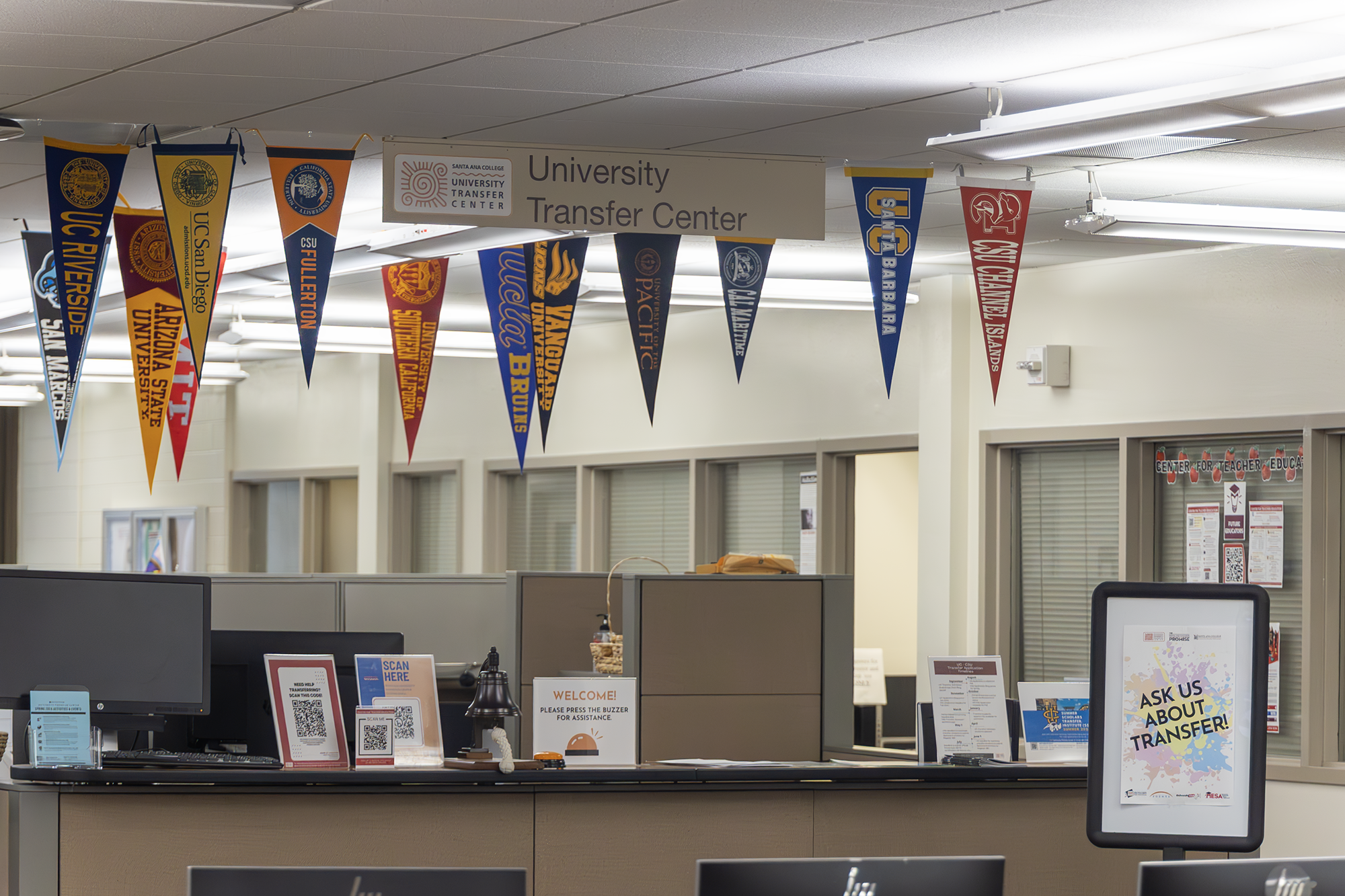 Transfer center check in desk displays the flags of the colleges most frequently transferred to .