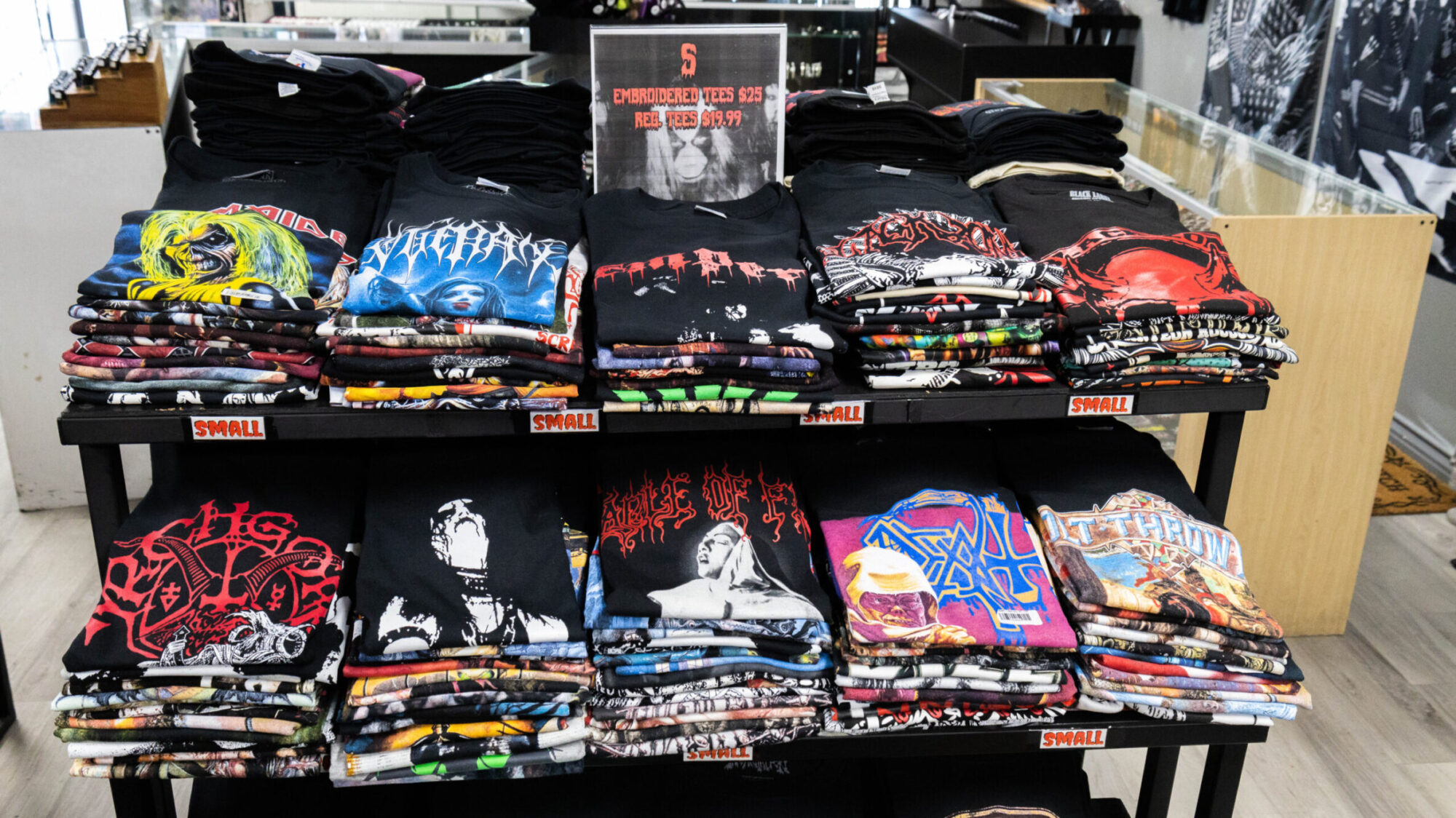 A shelf of t-shirts of black and death metal shirts