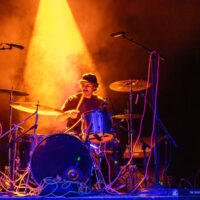 A drummer under orange light