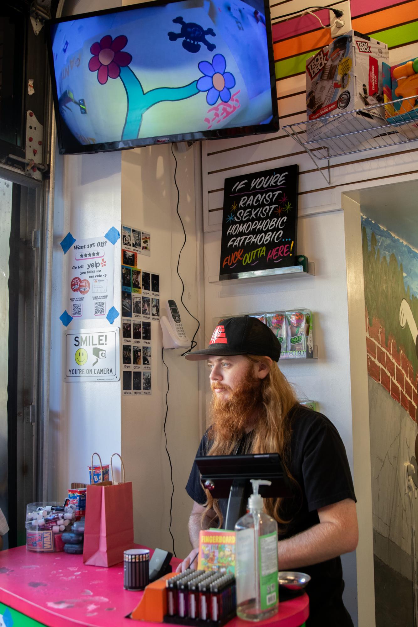 Two images sit side-by-side. On the left, is the store's cashier standing at the register. On the right, is a young man showing off his mini skateboard moves.
