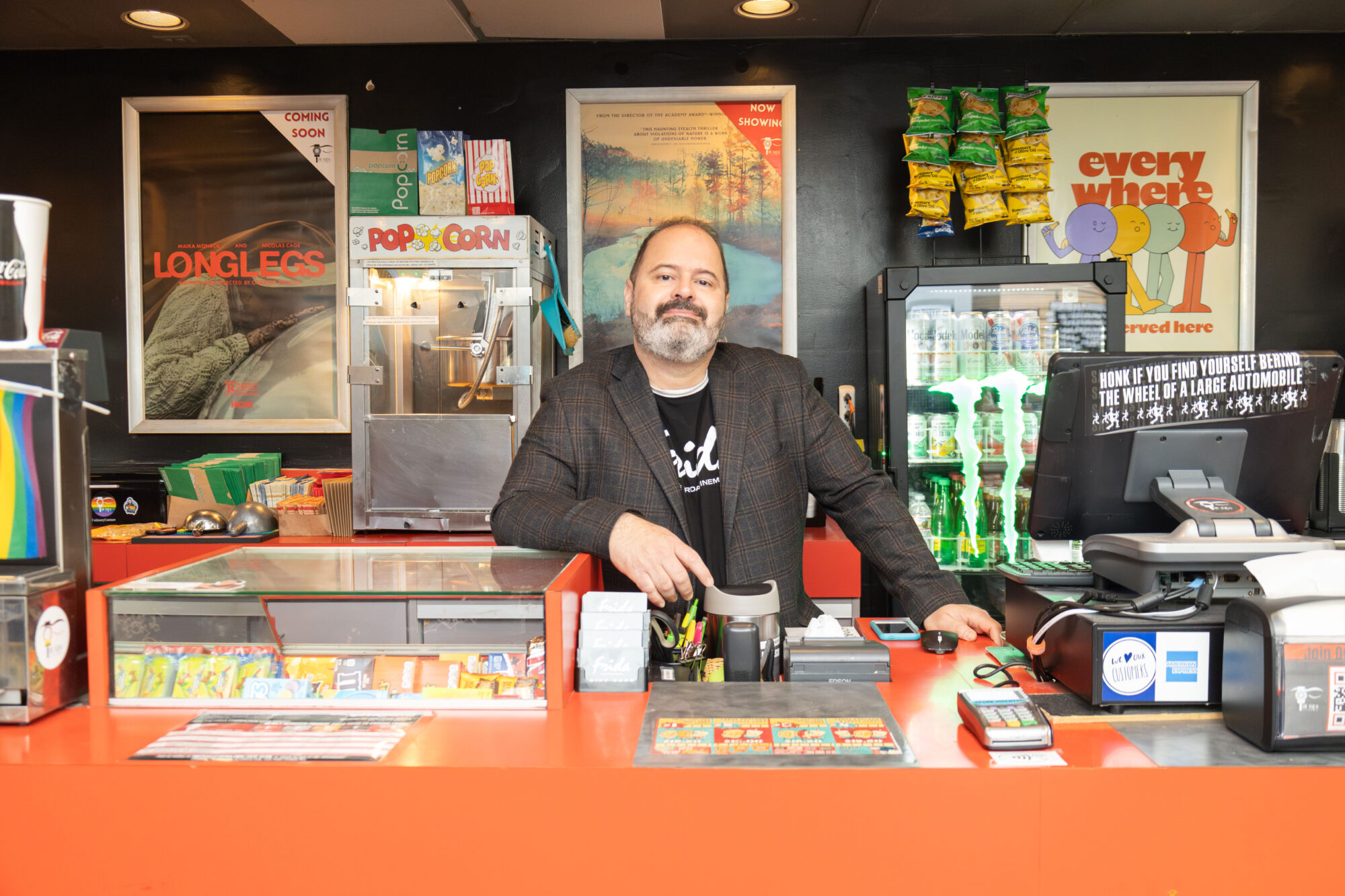 A man standing behind a movie theater counter