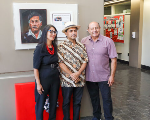 Three people standing in front of a mural