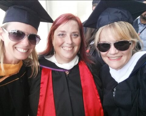 Three people in graduation gowns