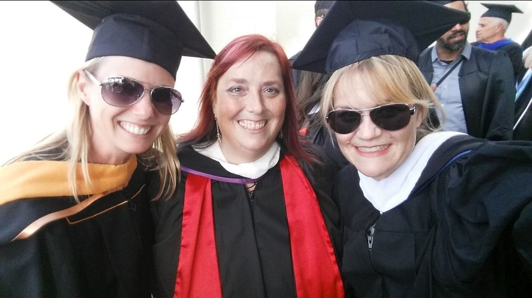 Three people in graduation gowns