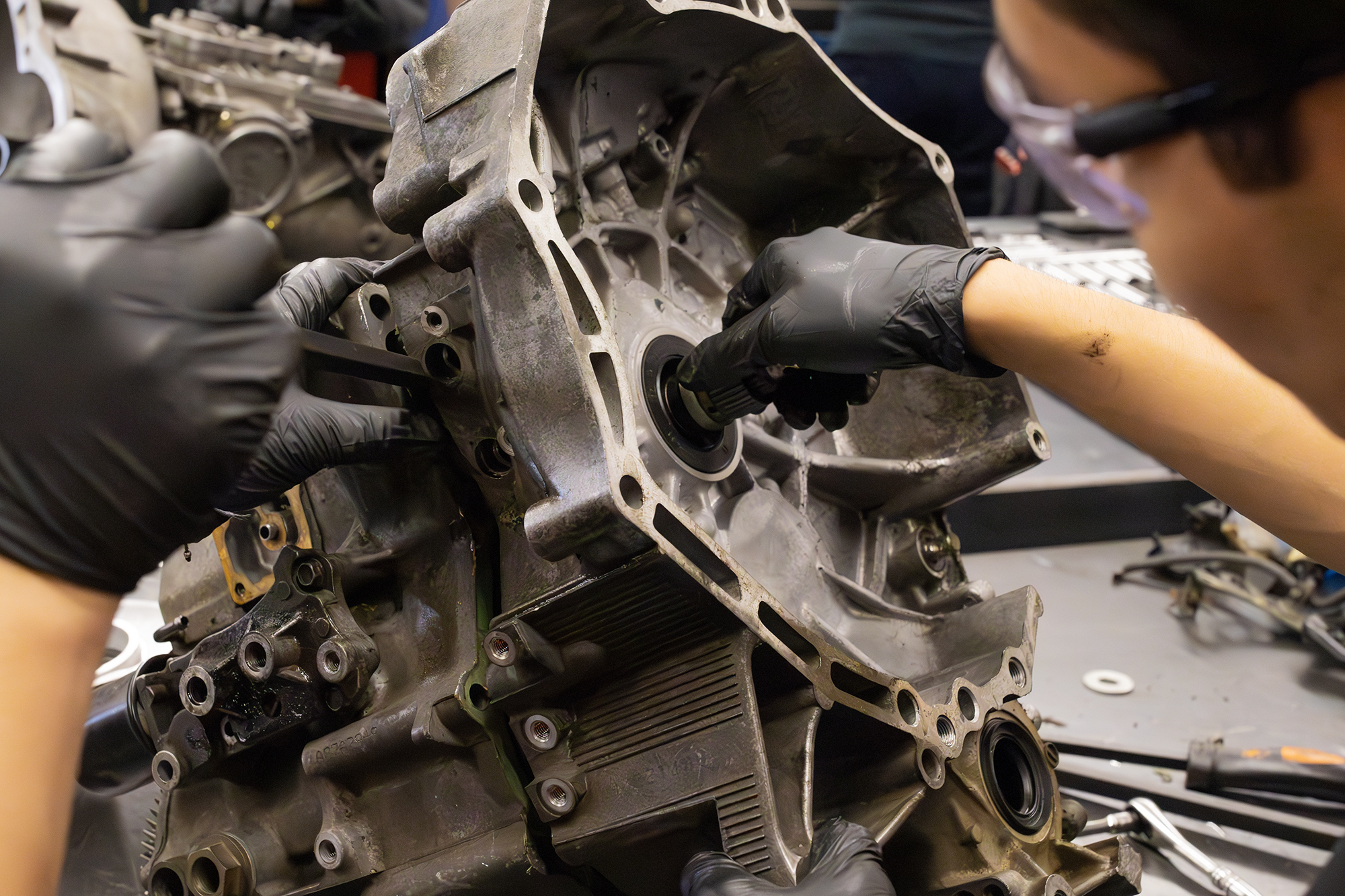 Detailed work as a student inspects a partially assembled drivetrain component