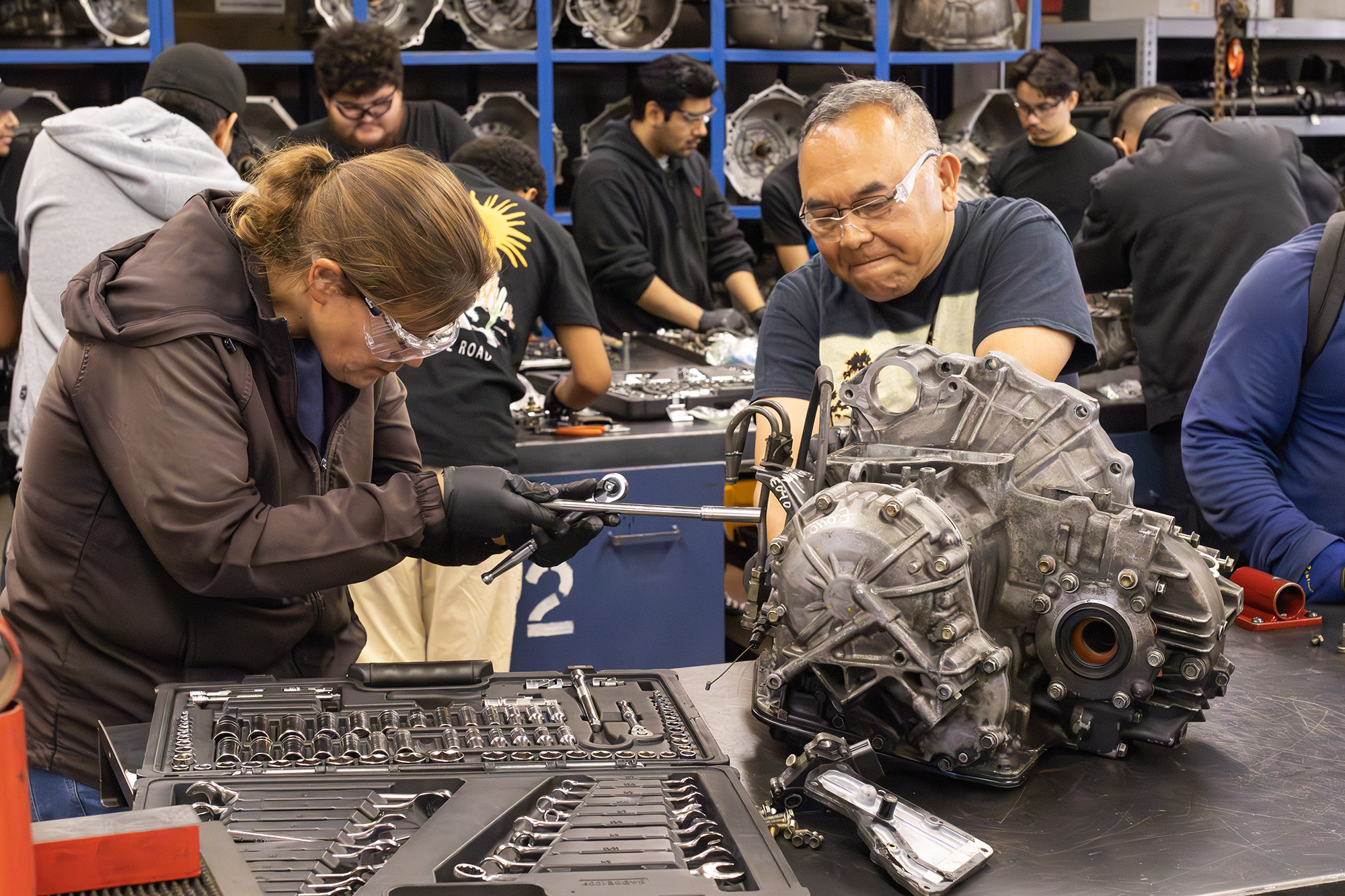 Two students disassemble a transmission.