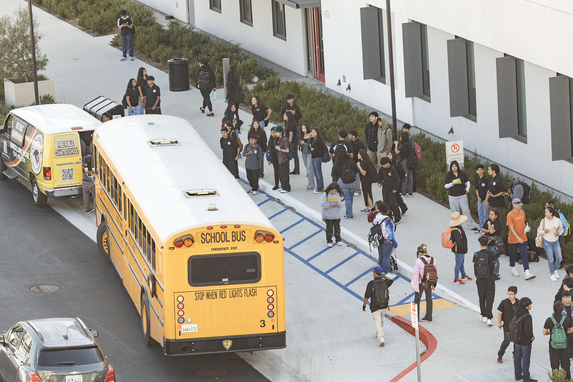 High school students boarding buses and transit vans to go home