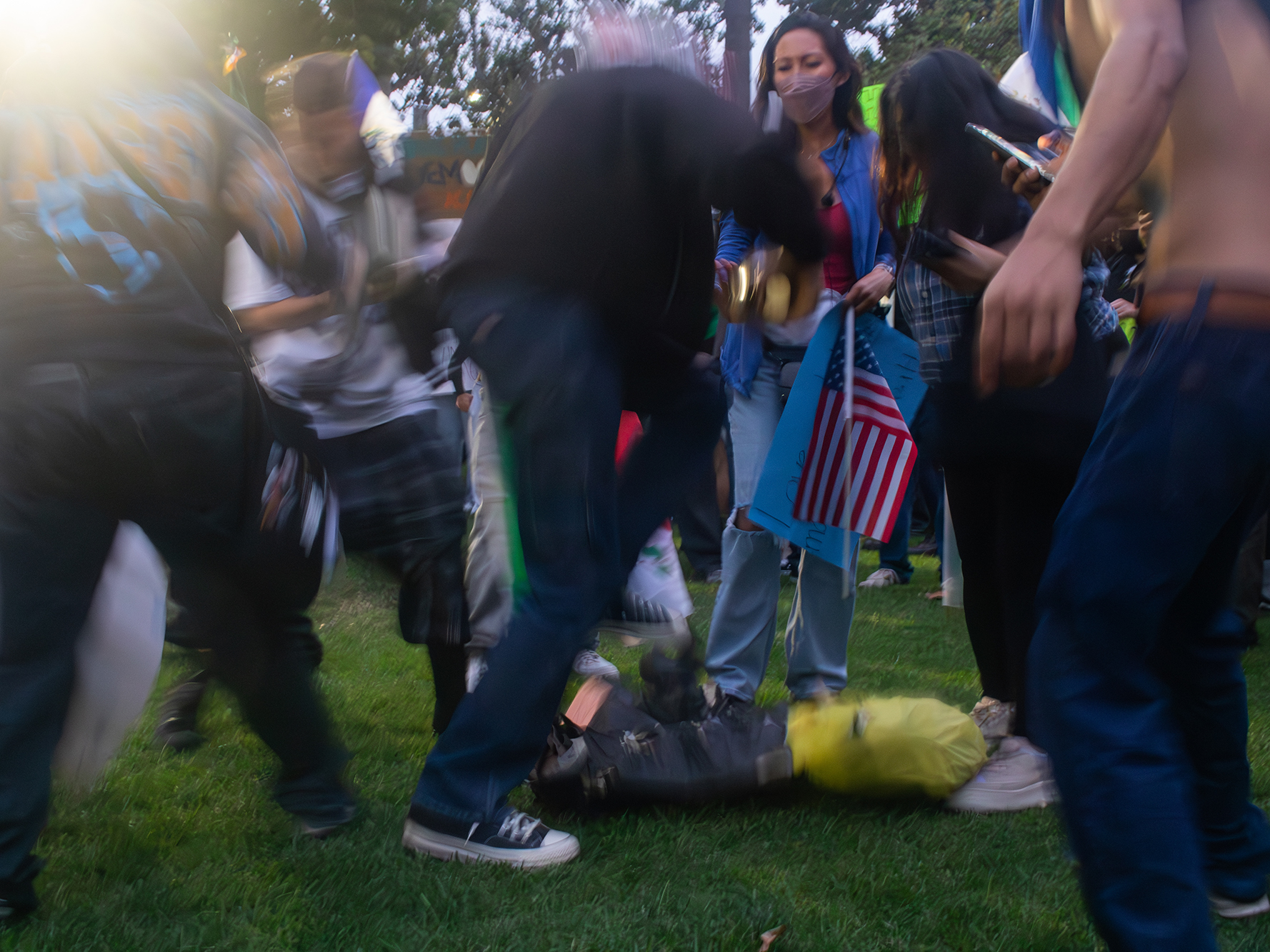 Protesters breaking a Trump piñata