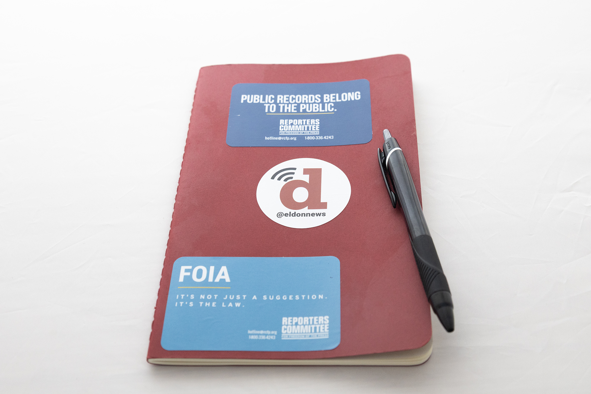 A red journal with stickers and a pen