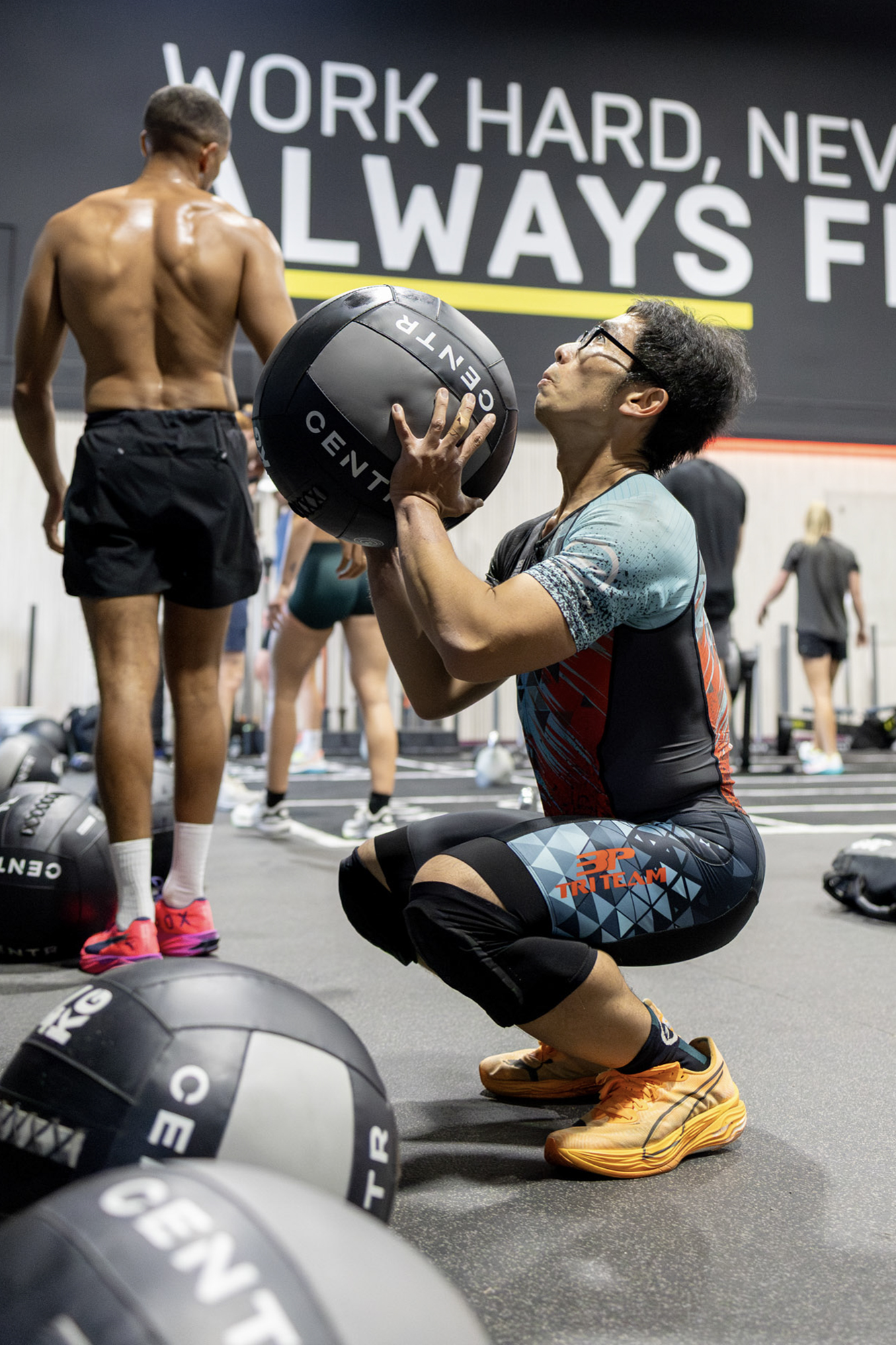 Man in athletic clothing trains with a weighted medicine ball.