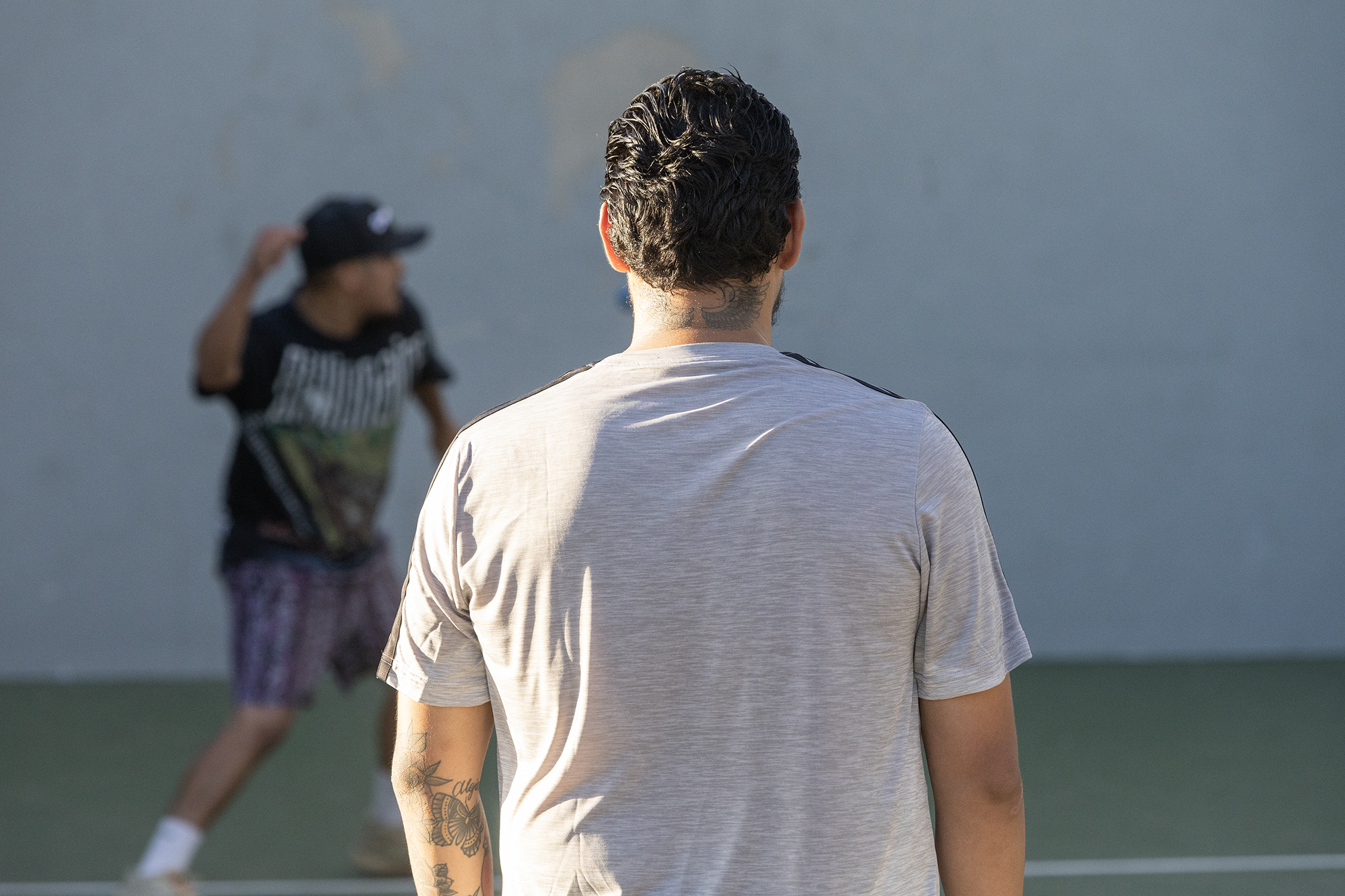 A man with a tattoo on the back of his neck facing away from the camera.